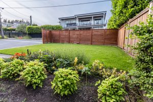 backyard with fence, gardens and grass